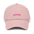 A light pink cotton baseball cap with 'good fish' embroidered in pink on the front, shown against a plain white background.